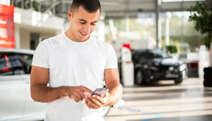 young man checking his phone dealership (1)