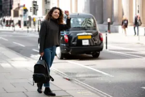 mujer joven preparandose para detener un taxi en la ciudad