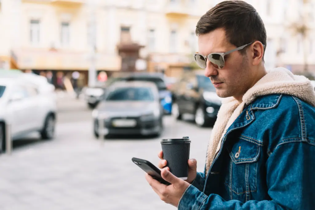 hombre moderno usando smartphone en ciudad