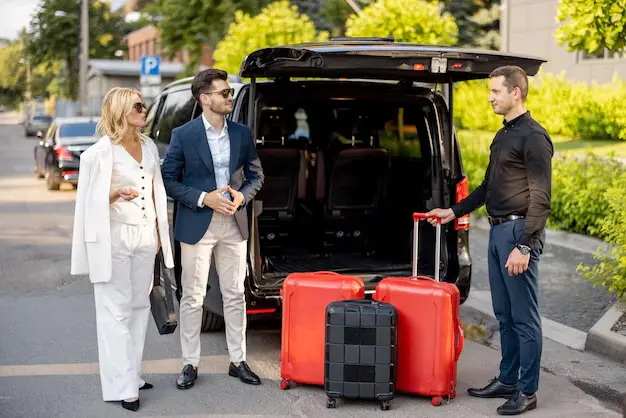 pareja negocios cerca taxi minivan maletas chofer