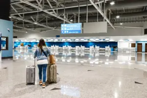mujer camina por el aeropuerto con maletas
