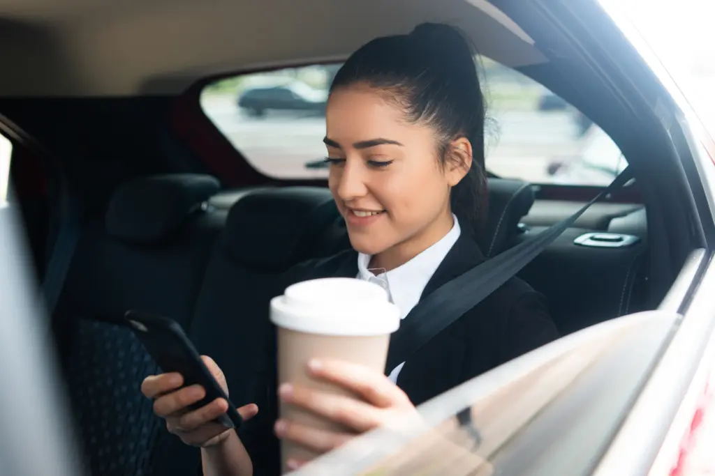 retrato de mujer de negocios con su telefono movil camino al trabajo en un coche concepto de negocio