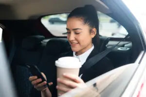 retrato de mujer de negocios con su telefono movil camino al trabajo en un coche concepto de negocio
