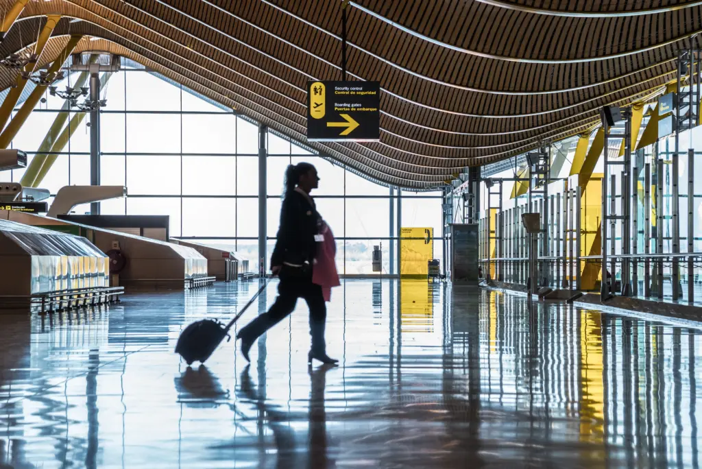 terminal del aeropuerto con gente moviendose siluetas y rayos de sol