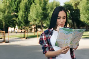 young woman looking map thinking park