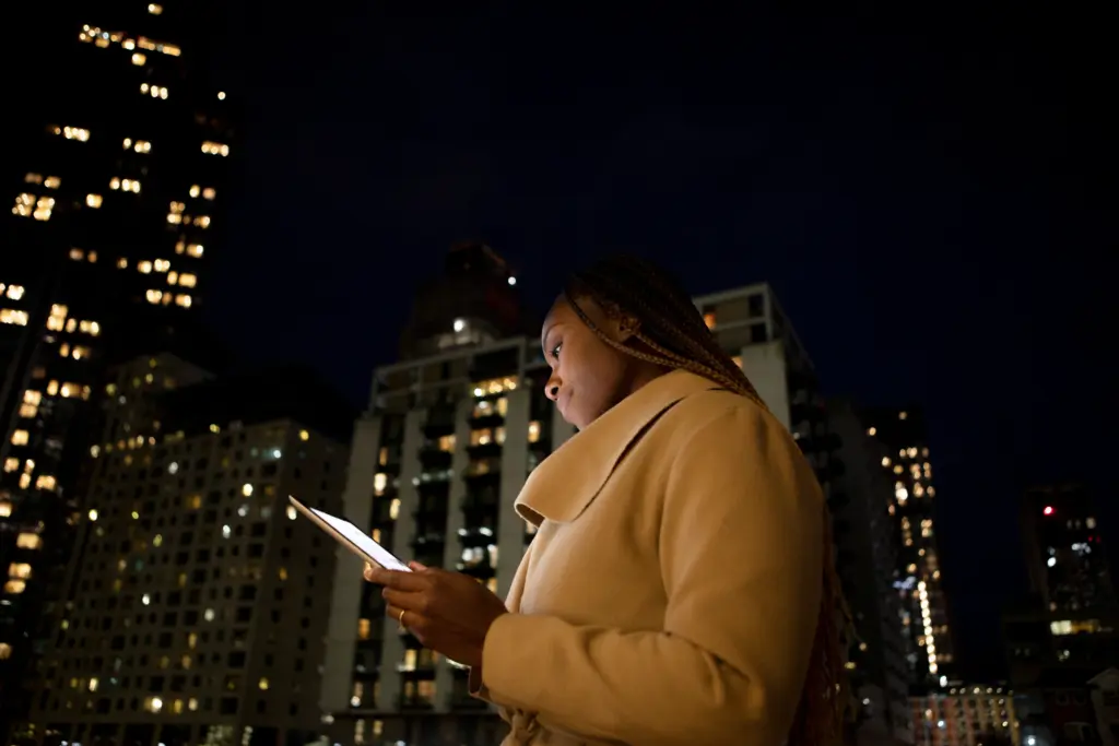 mujer que usa una tableta para trabajar al aire libre