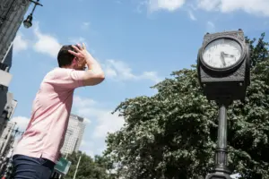 hombre mirando el reloj de la calle