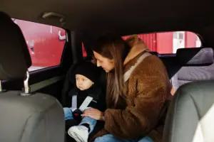 joven madre y nino en coche asiento de bebe en silla seguridad conduccion concepto