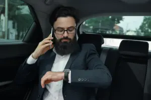 businessman while traveling by car back seat using smartphone