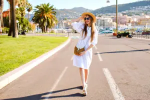 young woman posing wearing trendy elegant feminine dress straw accessories