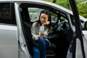 woman using smartphone electric car