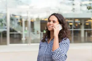 mujer alegre positiva hablando por telefono movil
