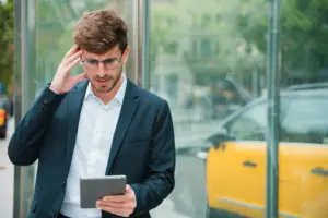 hombre de negocios joven contemplado que mira la tableta digital