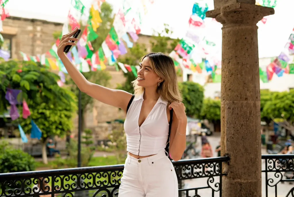 mujer sonriente tomando selfie vista lateral