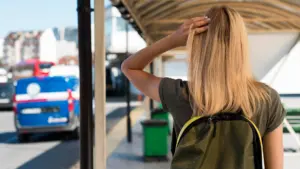 mujer de tiro medio con mochila en la estacion de autobuses