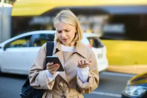retrato de una joven rubia confundida de pie en una calle concurrida con coches detras de ella mirando ()