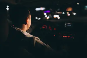 young man driving his car night time ()