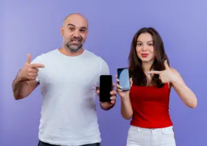 pareja adulta segura mostrando telefonos moviles y apuntando ellos