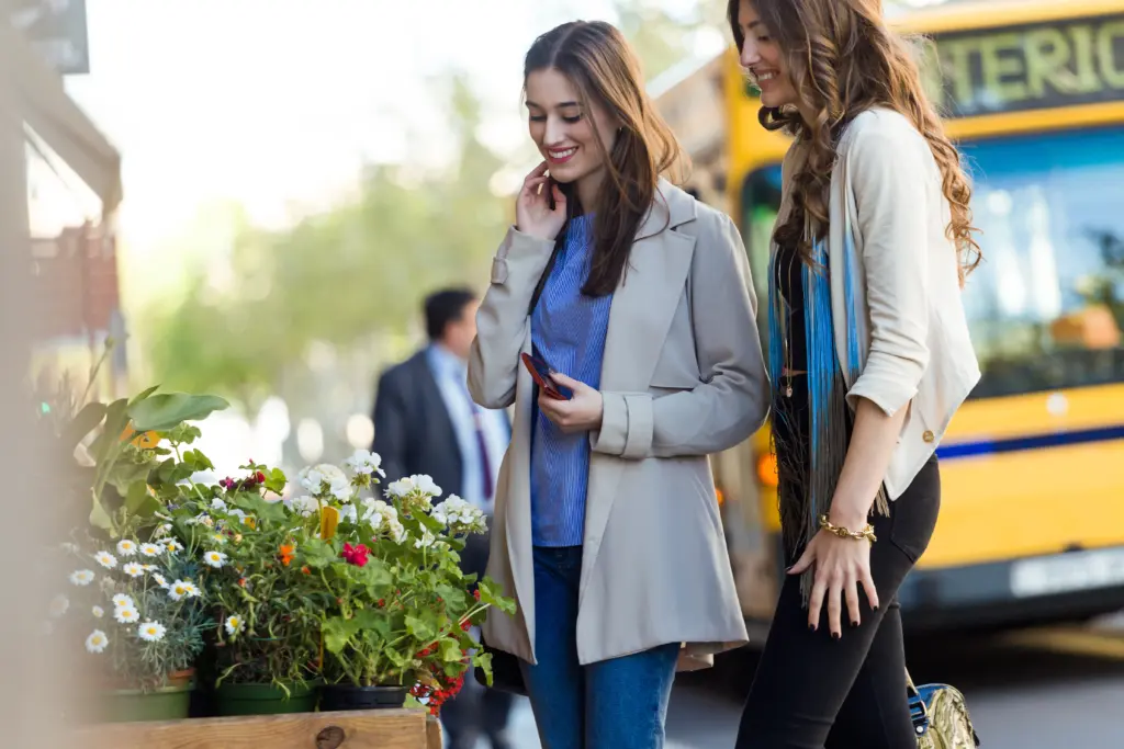 dos hermosas mujeres jovenes caminando y hablando en la calle